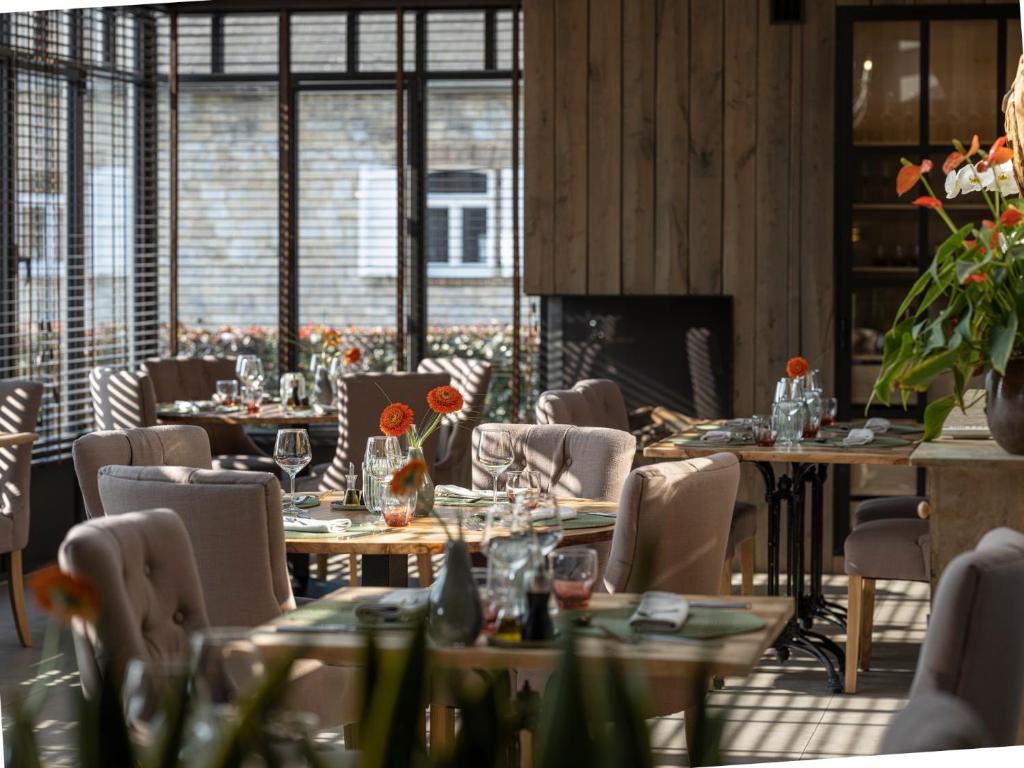 un restaurante con mesas y sillas y una chimenea en Hotel le Fenil, en Celles