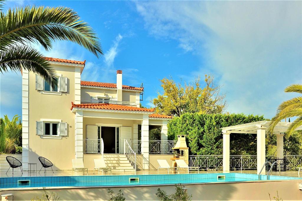 a house with a swimming pool in front of it at Sea Wave Villa Kefaloniaprivatevillas in Trapezaki