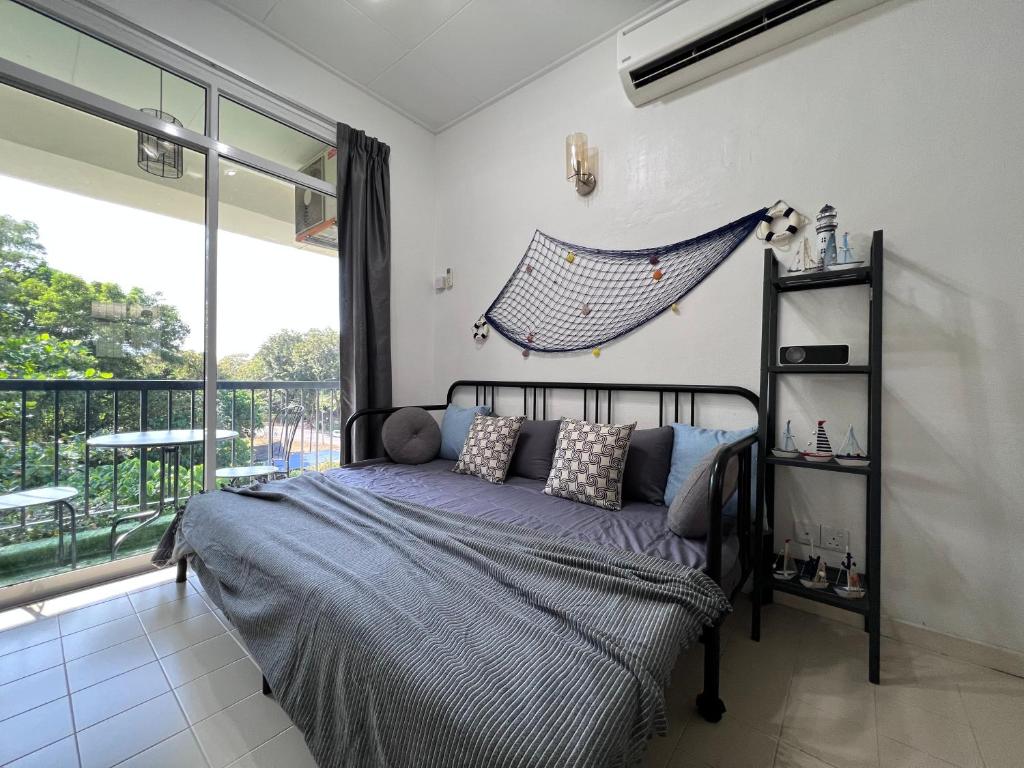 um quarto com uma cama e uma grande janela em EE's Beach House - Homestay 3 min walk to beach em Batu Ferringhi