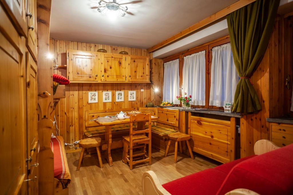 una cocina con armarios de madera, mesa y sillas en Casa-chalet, in centro a Courmayeur!, en Courmayeur