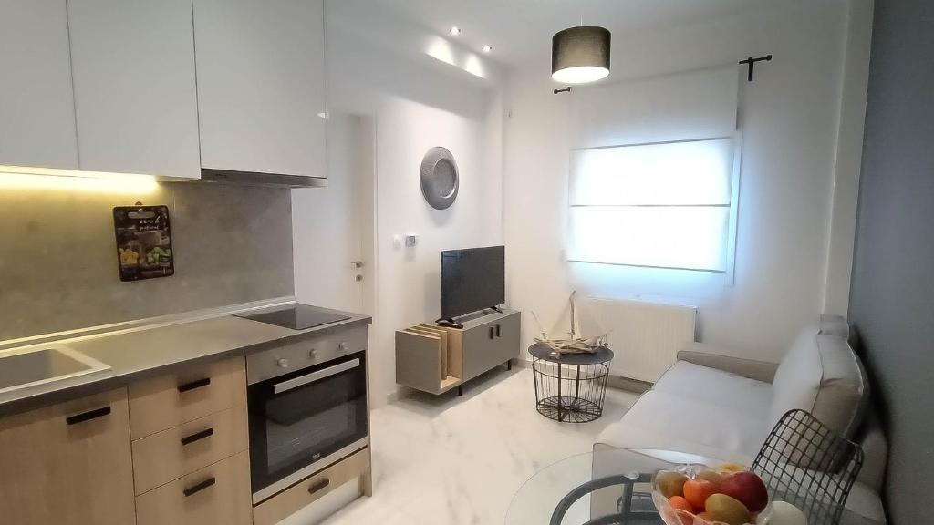 - une cuisine avec un canapé et une table avec un bol de fruits dans l'établissement Cozy fully equipped apartment Thessaloniki, à Thessalonique