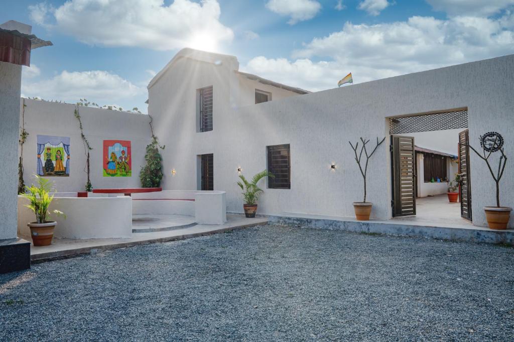 a white building with potted plants in a courtyard at Takshshila Park And Resorts in Jagdalpur