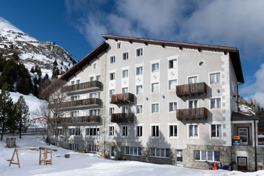 a large white building in the snow at Hotel Grischuna in Bivio