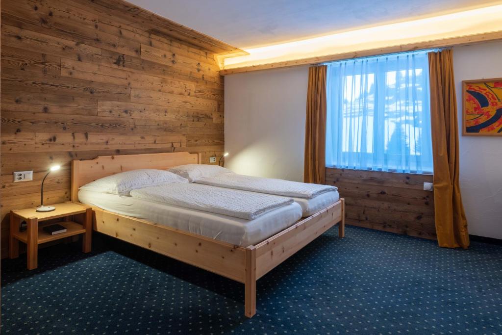 A bed or beds in a room at Hotel Grischuna