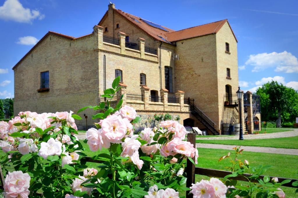 a building with pink roses in front of it at Folwark Pszczew in Pszczew