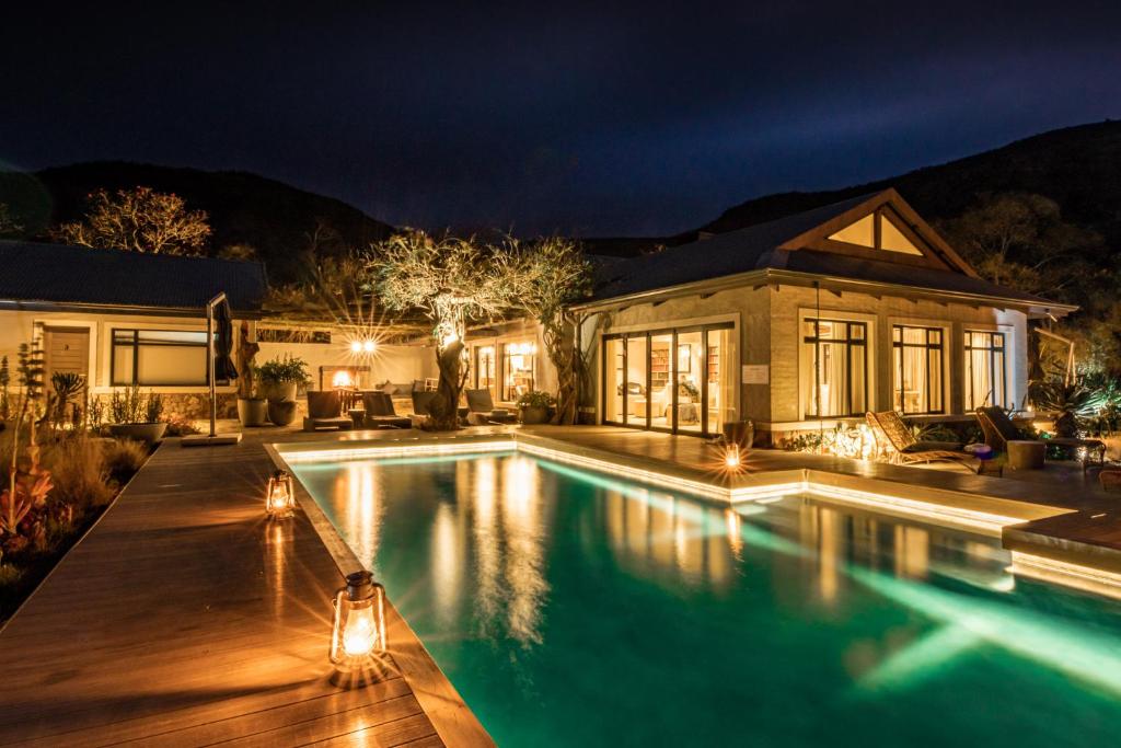 a swimming pool in front of a house at night at Valley Lodge - Babanango Game Reserve in Dundee