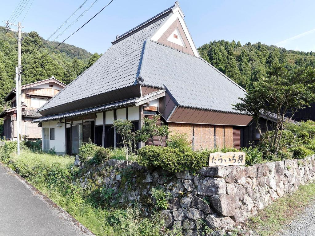 a house on a hill with a stone wall at Taraichitei in Takashima