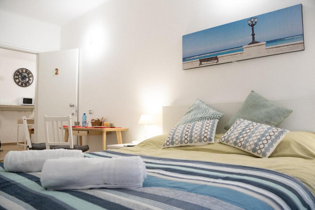 una camera da letto con un letto con cuscini blu e bianchi di B&B Alighieri 97 a Bari