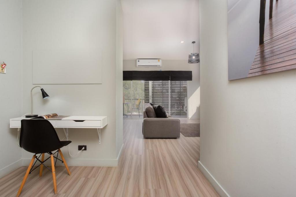 a white room with a desk and a chair at Studio 365 Serviced Apartments in Chiang Mai