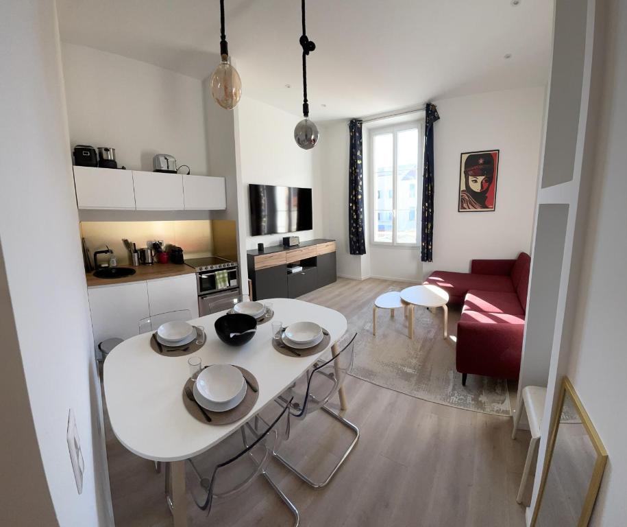 cocina y sala de estar con mesa blanca y sillas en LEC2-3 Pièces rénové - Centre Ville, en Cannes