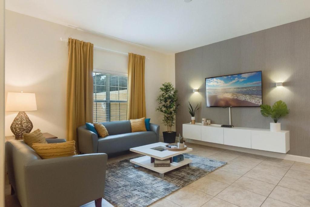 ein Wohnzimmer mit einem Sofa und einem Tisch in der Unterkunft Townhome w pool near Disney & Orlando Attractions in Kissimmee