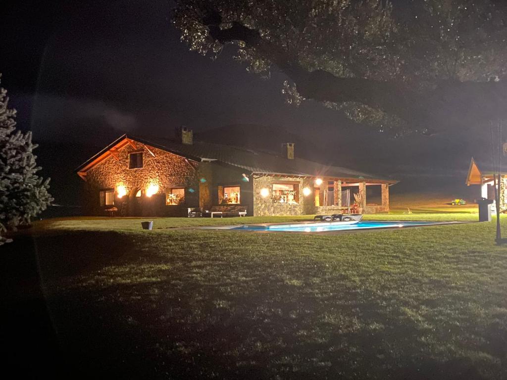 ein Haus in der Nacht mit Pool davor in der Unterkunft Ca l’Andreu Suites in Alás