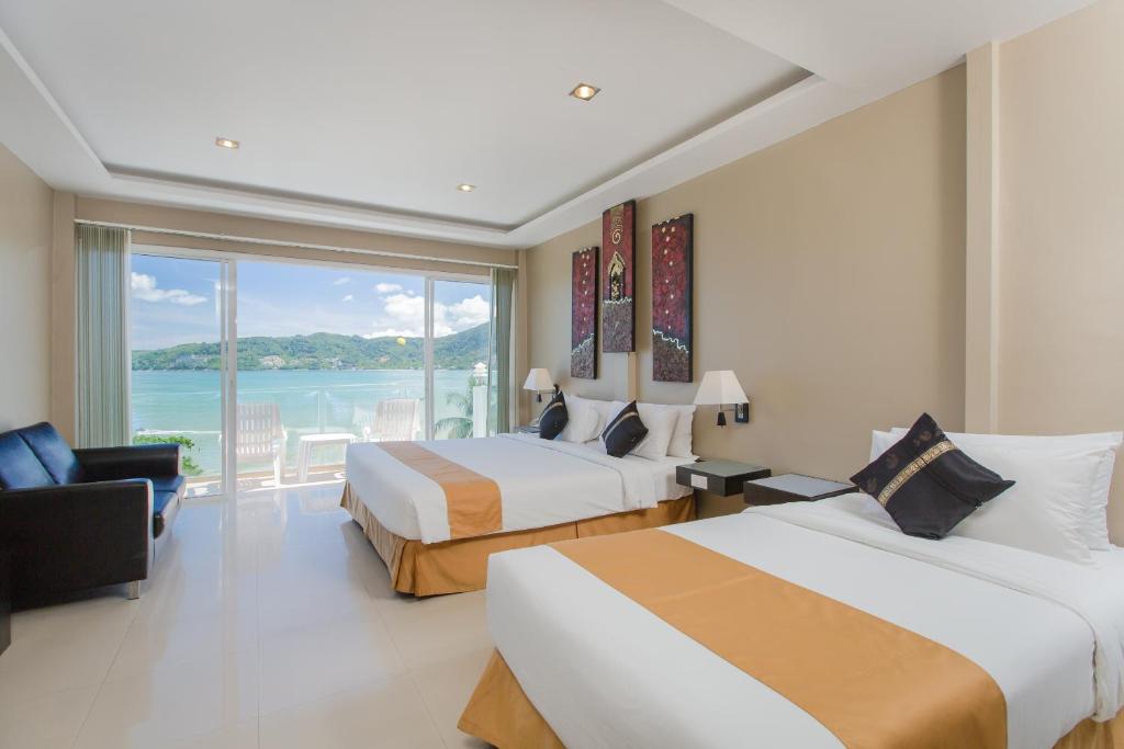 a hotel room with two beds and a large window at The Front Hotel and Apartments in Patong Beach