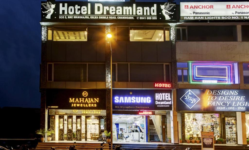 a building with signs on the side of it at night at Hotel Dreamland Chandigarh in Chandīgarh