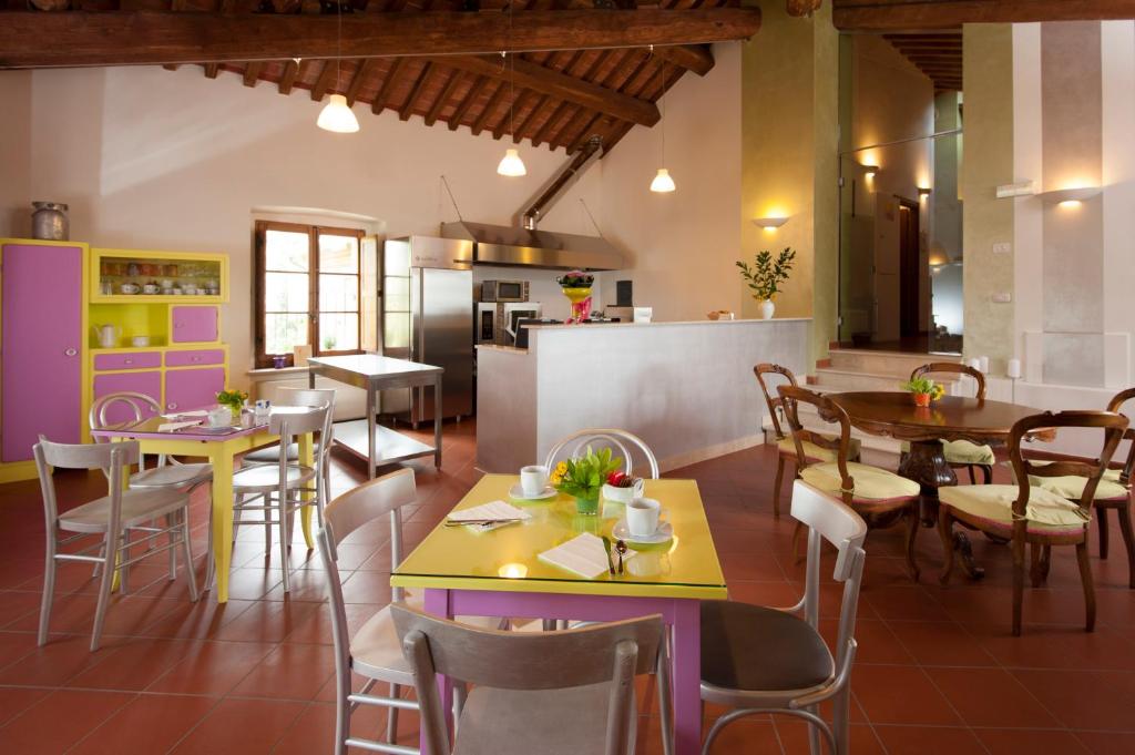 a restaurant with tables and chairs and a kitchen at Antico Granaione in Rapolano Terme