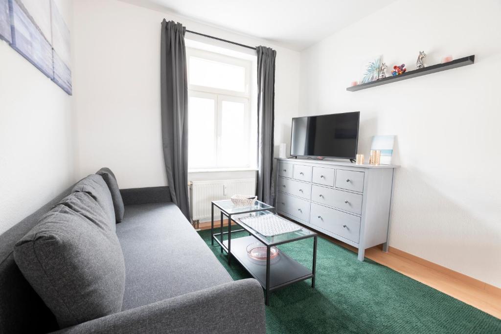 sala de estar con sofá y TV en gemütlich und modern mit großem Balkon, en Zwickau