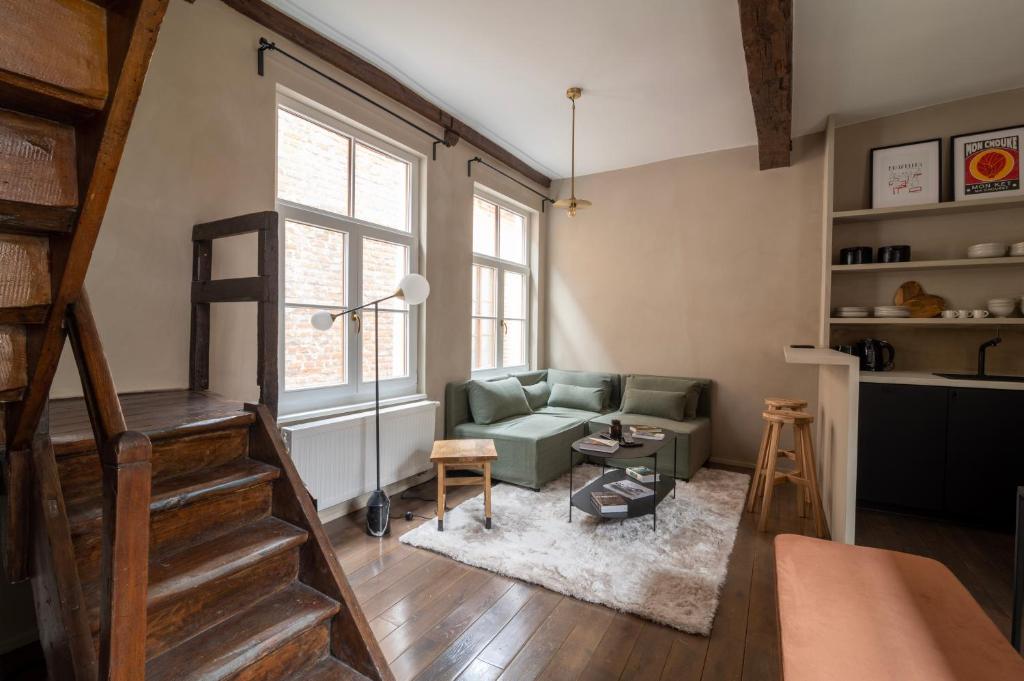 uma sala de estar com um sofá e uma cadeira em Charming House in Le Sablon em Bruxelas