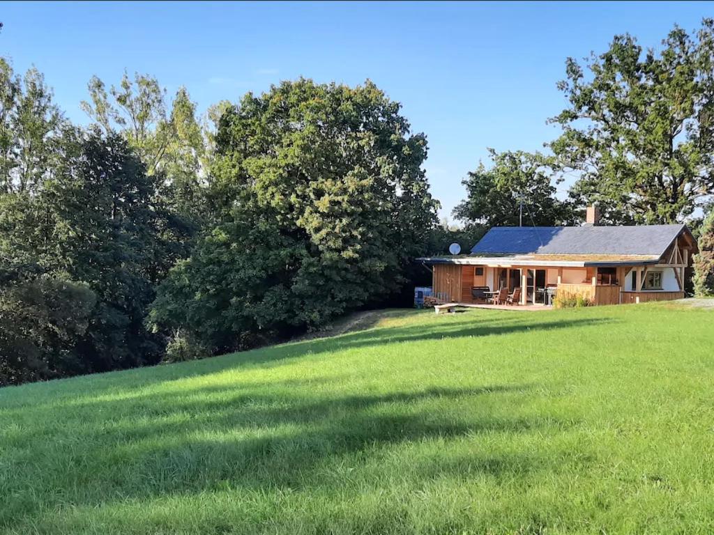 une maison sur une colline avec une grande pelouse dans l'établissement Jagdhaus im Grünen, mit Sauna, à Kulmbach