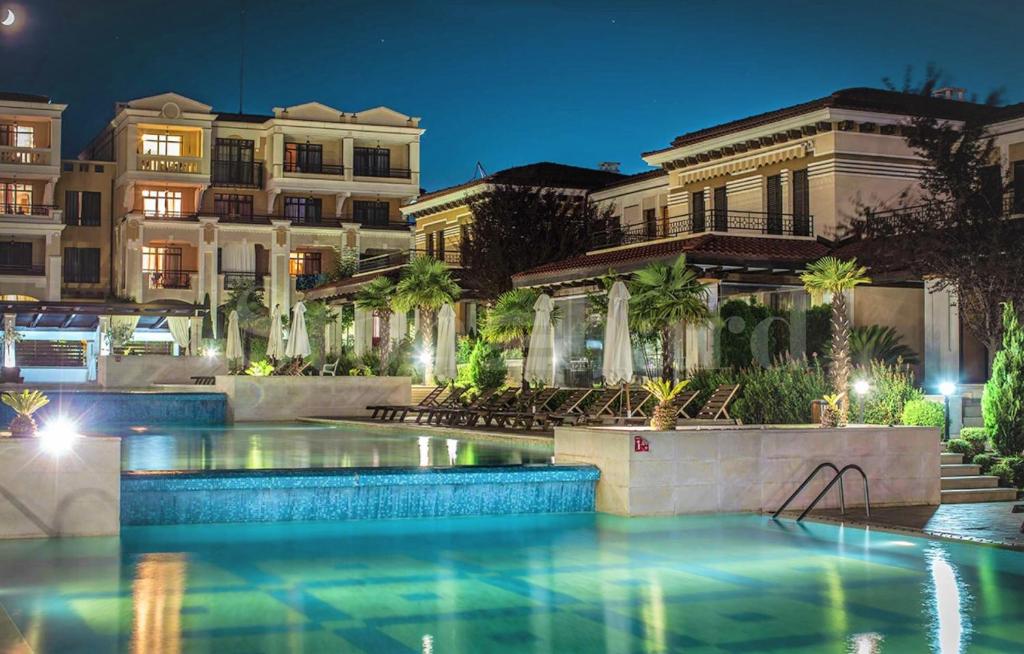a swimming pool in front of a building at night at art STUDIO in Green Live beach resort - at ground floоr with Terrace and green patio just infront ot the Pool in Sozopol
