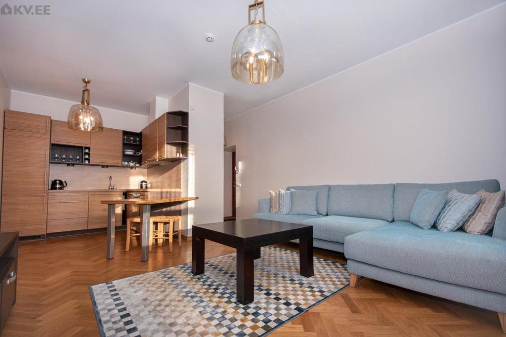 sala de estar con sofá azul y mesa en Stylish apartment in the heart of Pärnu, en Pärnu