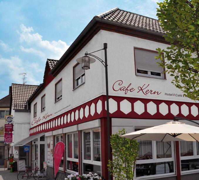 a white building with an umbrella in front of it at Hotel Cafe Kern in Großostheim