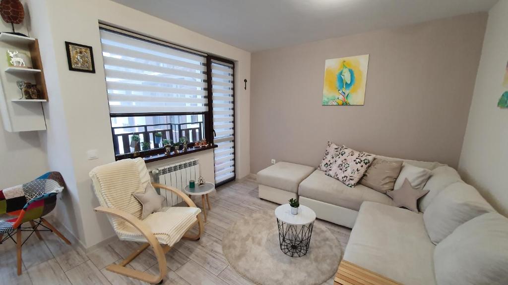 a living room with a couch and chairs and a window at Borovets Cozy Mountain Apartments in Borovets