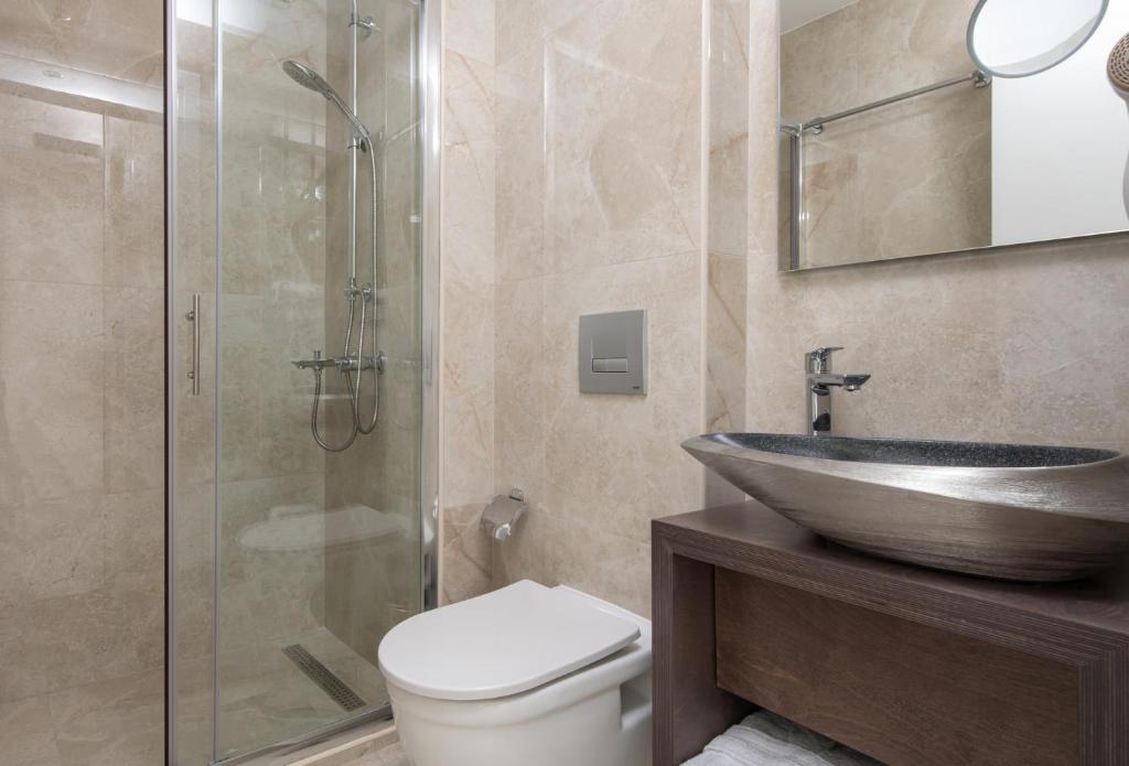 a bathroom with a sink and a toilet and a shower at Crist Luxury Apartments in Nea Potidaea