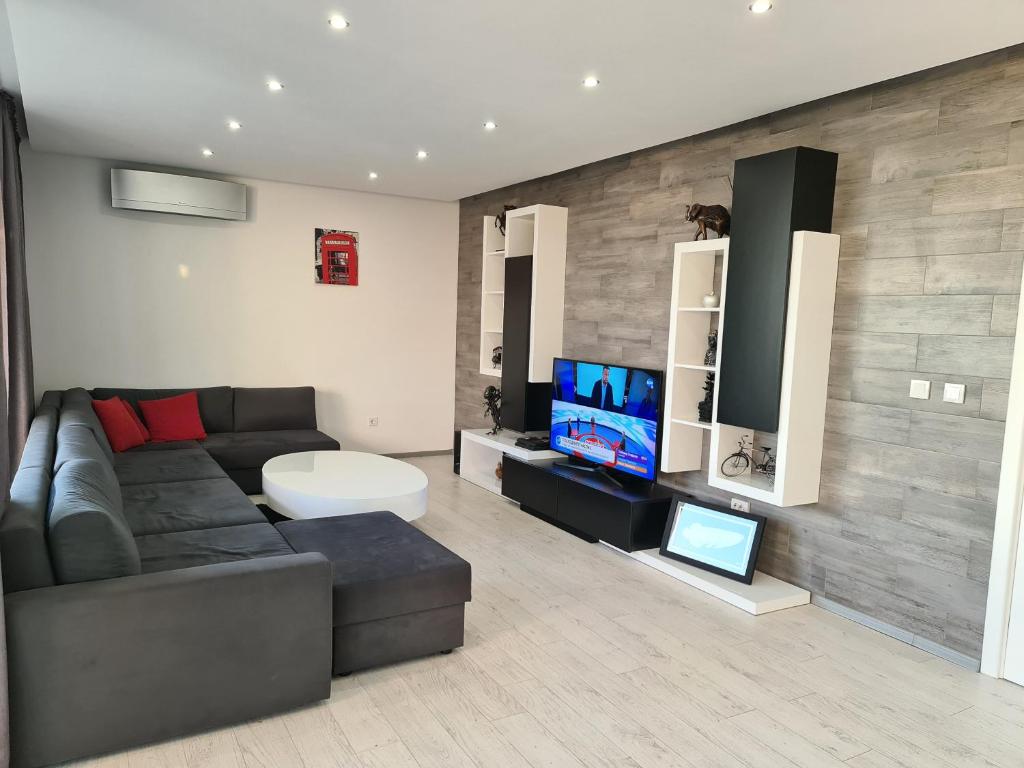 a living room with a couch and a tv at Villa ARUBA in Balchik