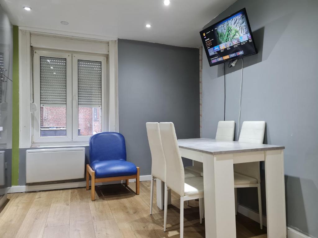 a dining room with a table and chairs and a tv at Duplex Savane, Lille in Lille