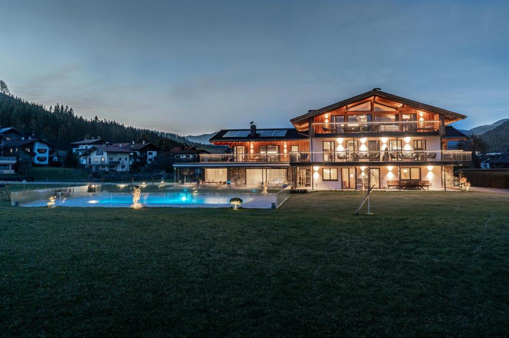 una casa grande con piscina frente a ella en Purest en Achenkirch