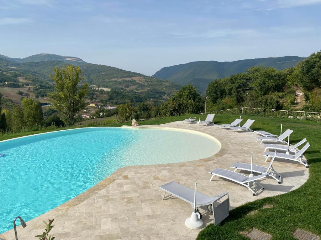 a pool with chaise lounge chairs and a swimming pool at Agriturismo Rocca del Nera in Preci