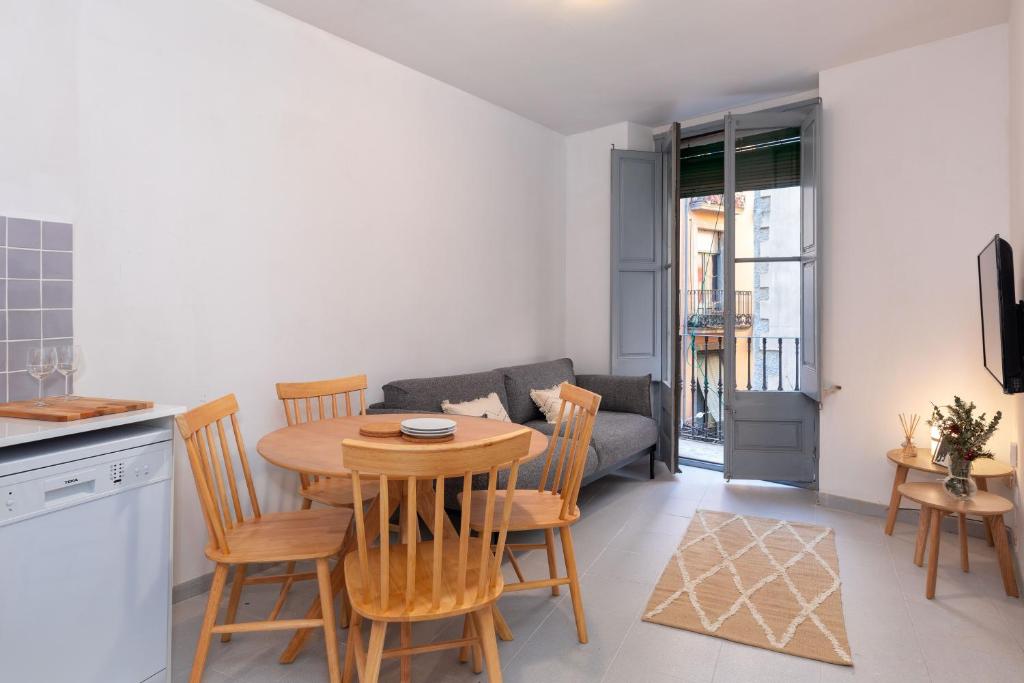 cocina y sala de estar con mesa y sillas en Flateli Cort Reial 10, en Girona
