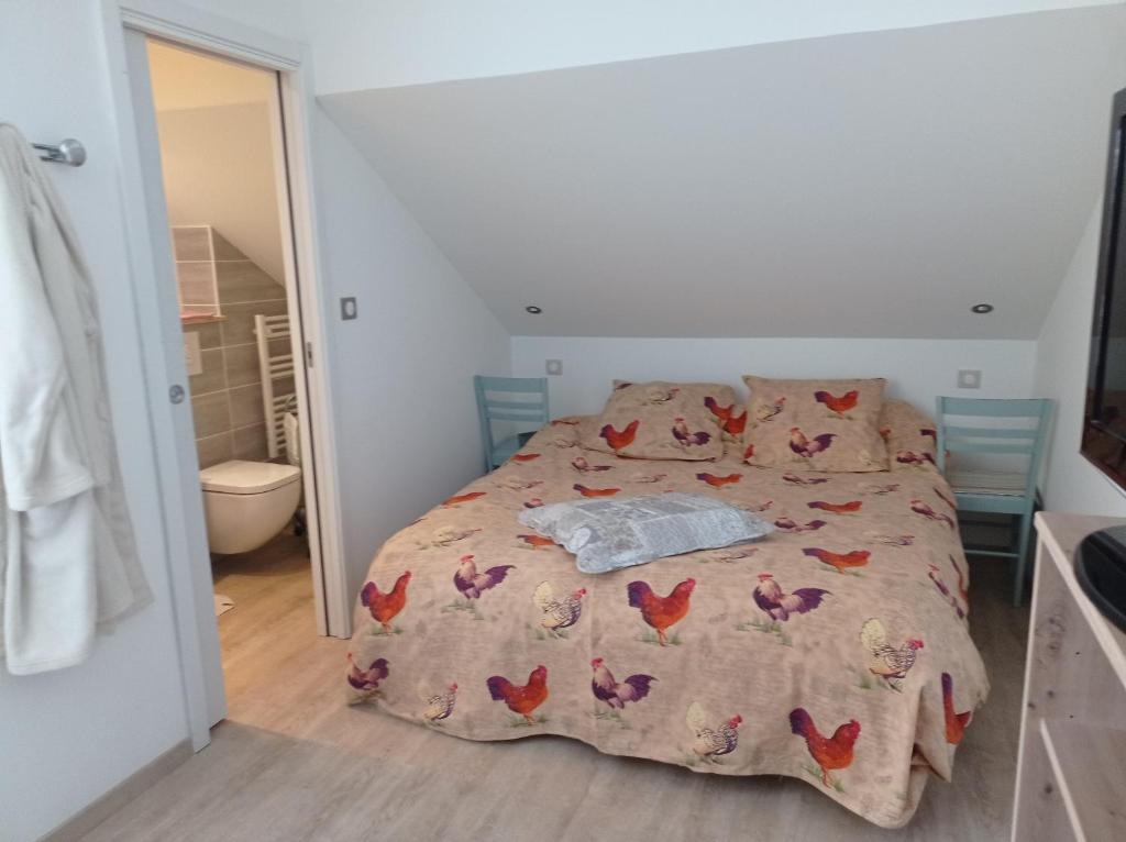 a bedroom with a bed with chickens on it at Les Clés de XOULCES in Cornimont