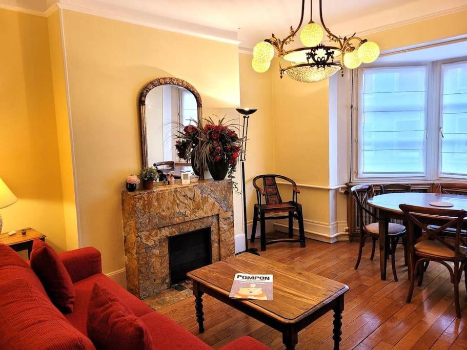 a living room with a fireplace and a table at Zassiettes et titin in Dijon