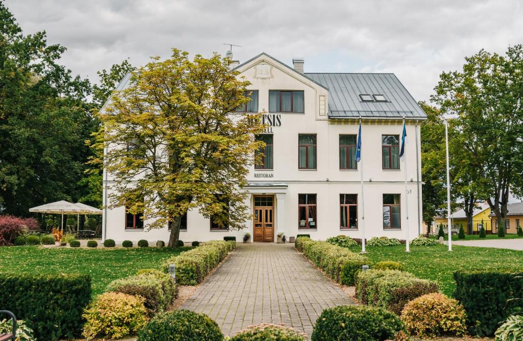 ein weißes Haus mit einem Baum davor in der Unterkunft Hotel Metsis in Valga