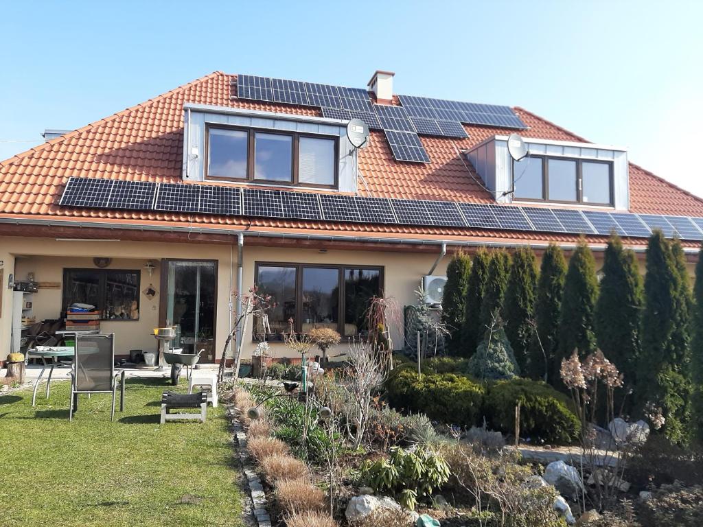 a house with solar panels on the roof at Garsoniera SOWA in Polanica-Zdrój