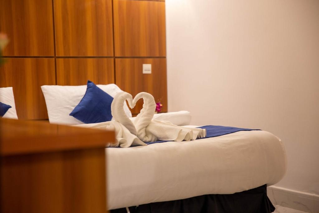 two swans towels on a bed in a hotel room at شاليهات الماسية الأولى in Jeddah