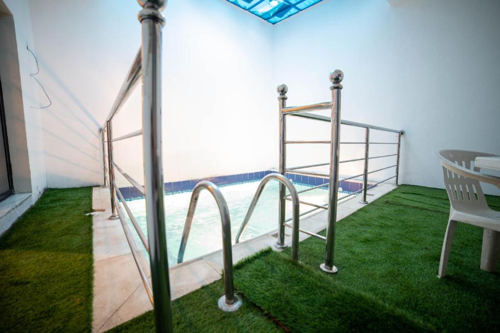 Pokój z basenem z łóżkiem piętrowym i trawą w obiekcie شاليه بمسبح خاص w mieście Dżudda
