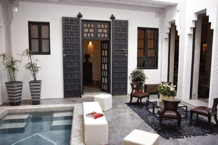 uma casa com piscina em frente a um edifício em Riad Heva em Marrakech
