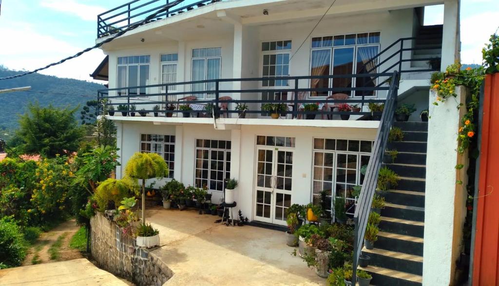 een wit huis met een balkon en een trap bij Zion in Nuwara Eliya