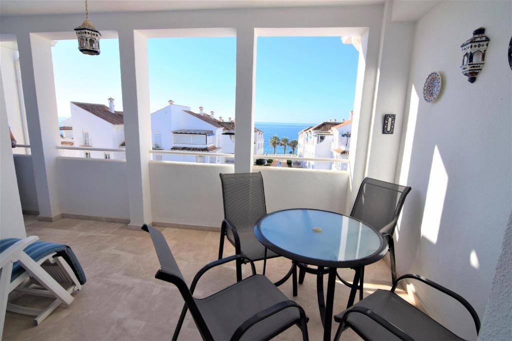 balkon ze stołem i krzesłami oraz oceanem w obiekcie Edf Fuentes A 2G - Eurosur w mieście Nerja