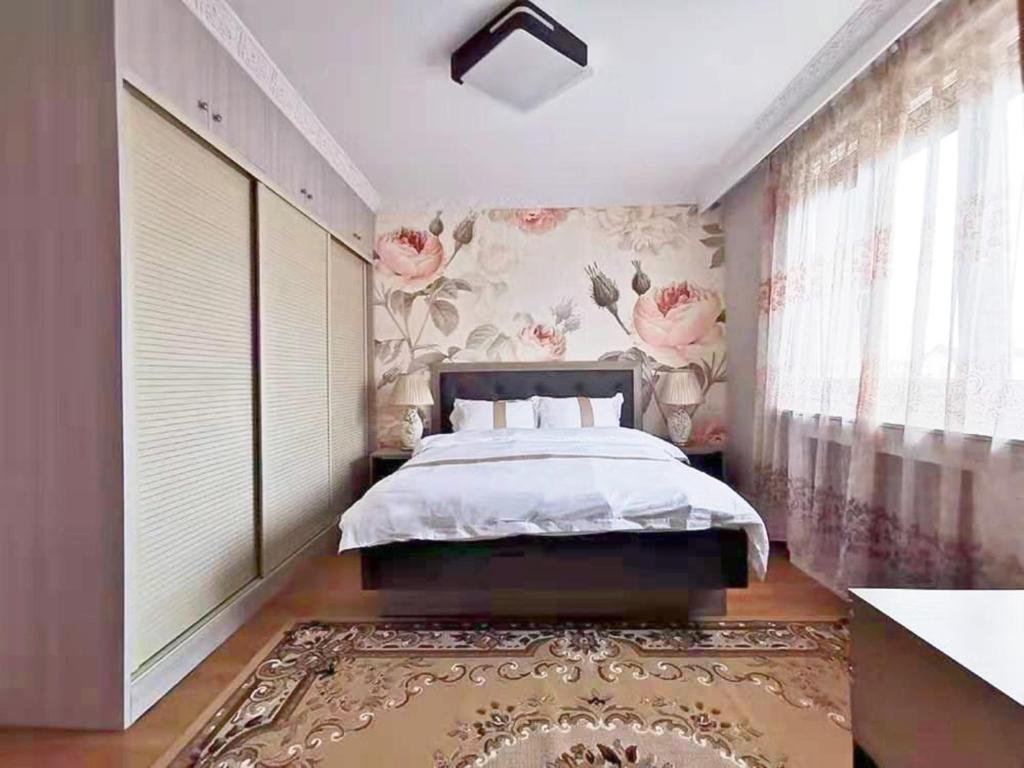 a bedroom with a bed and a floral wall at La Maison Charentonneau in Maisons-Alfort