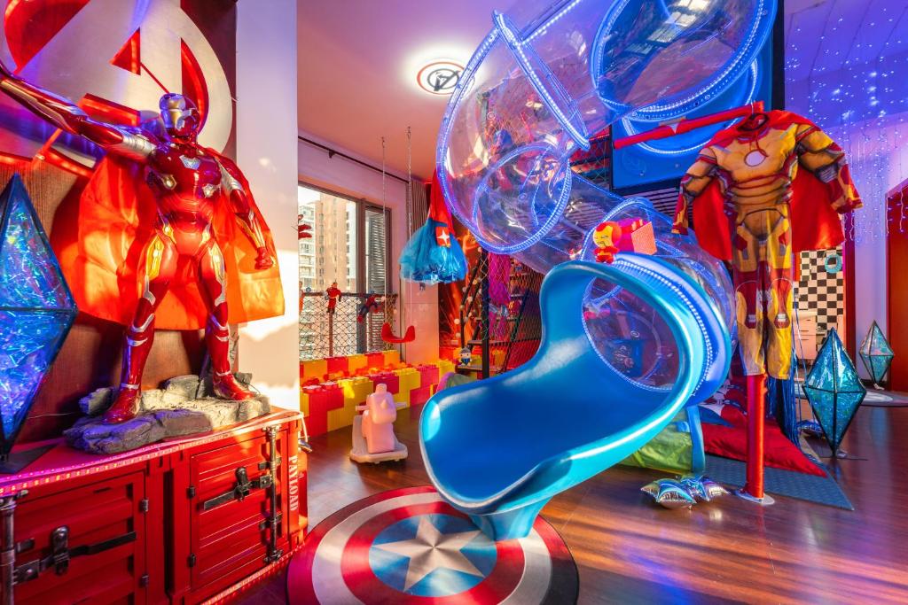 a room with superheroes and a blue slide at 咕噜小屋武汉店 in Wuhan