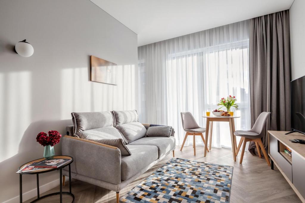 - un salon avec un canapé et une table dans l'établissement #stayhere Modern & Compact 1BDR Uptown Vilnius, à Vilnius