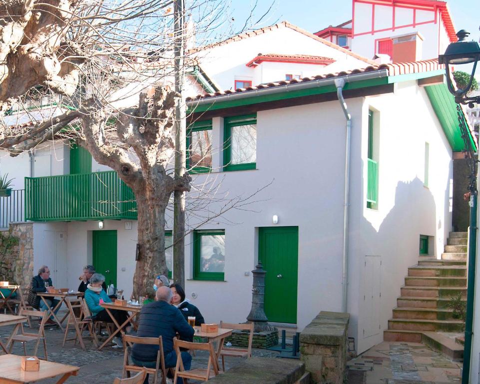 a group of people sitting at tables in front of a building at El puerto viejo in Getxo