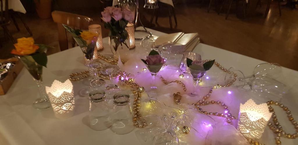 a white table with glasses and flowers and lights at Hotel-Restaurant Wilhelmsbad in Seesen