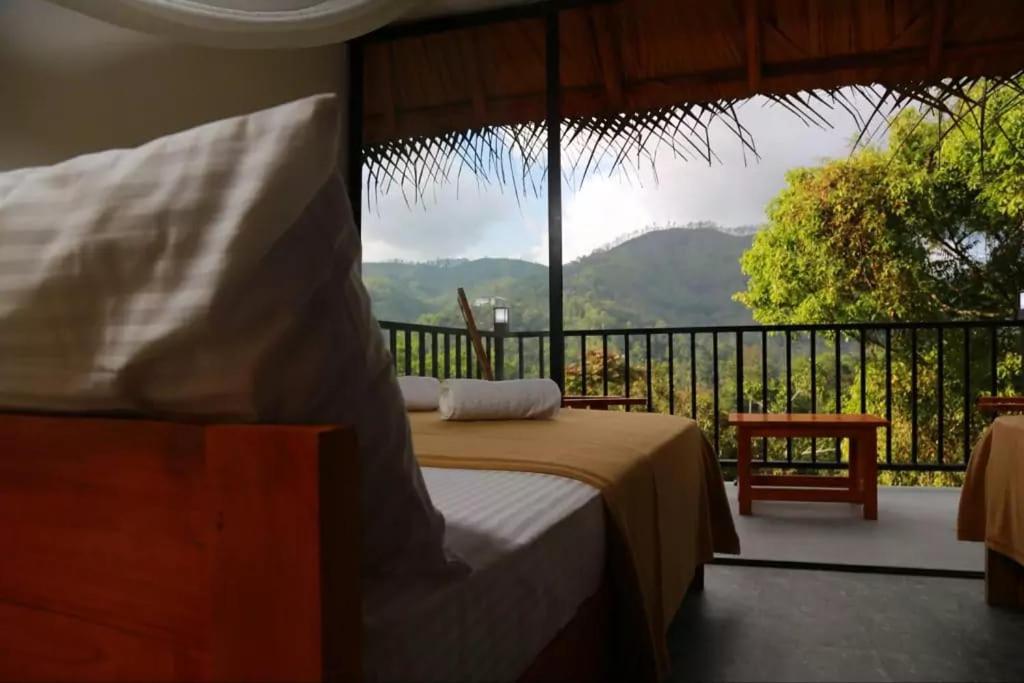 een slaapkamer met een bed en een balkon met uitzicht bij Ollie resort in Ella