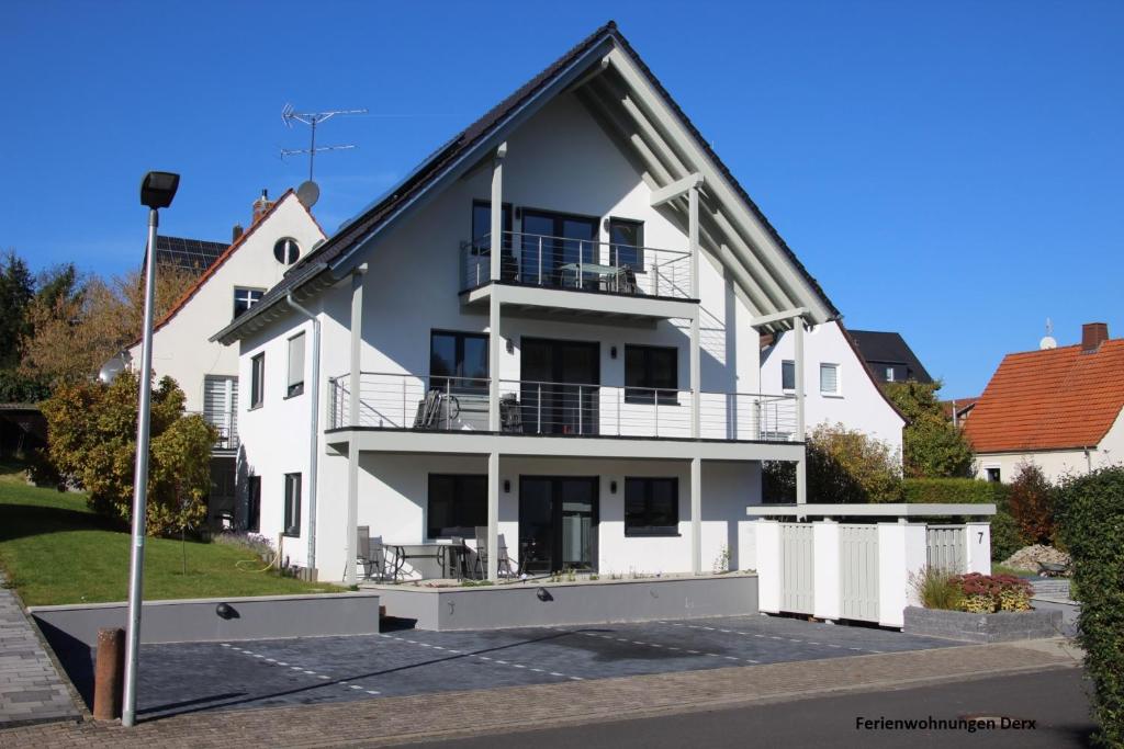 une maison blanche avec un toit noir dans l'établissement Ferienwohnung Helenenquelle, à Bad Wildungen