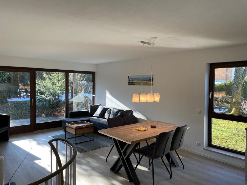 uma sala de estar com uma mesa e um sofá em Großzügiges Domizil, 90qm, mit Terrasse, Garten und Garage em Marquartstein