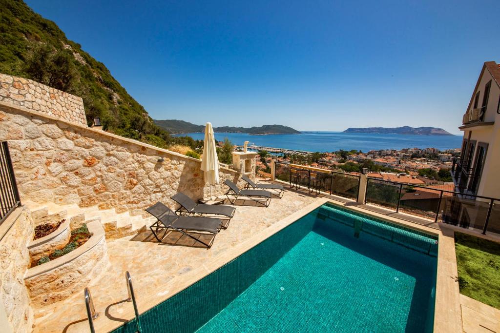 a villa with a swimming pool and a view of the ocean at Granda Apart in Kaş